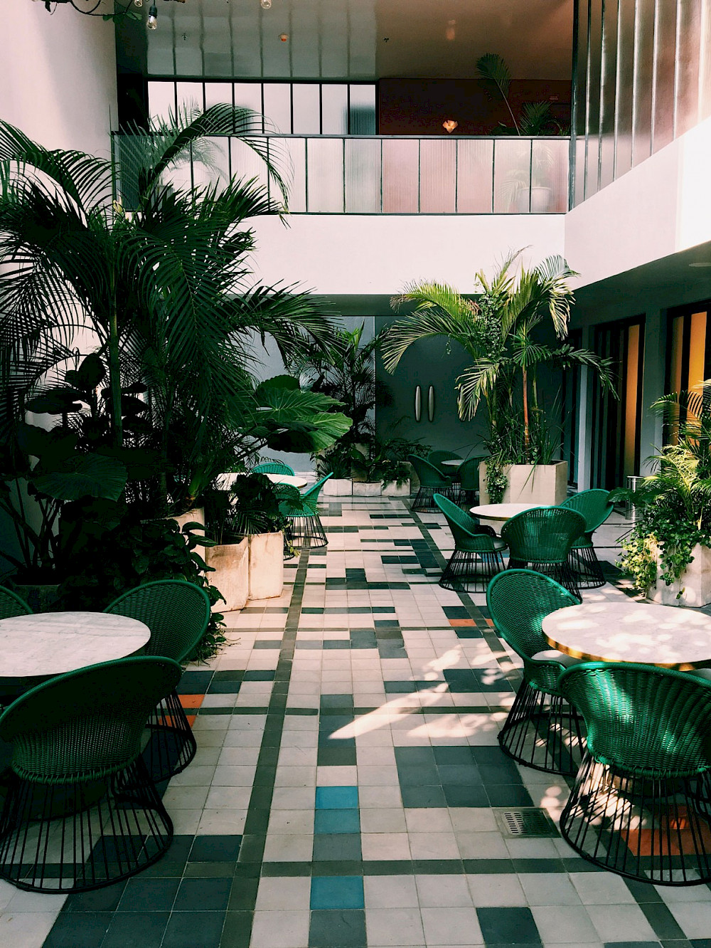 A calm plant-filled courtyard with tables for working